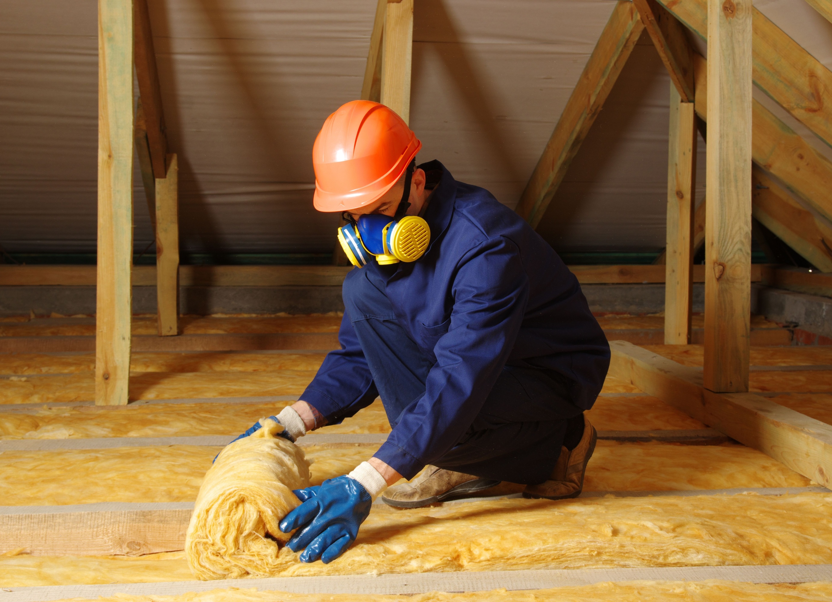 Worker insulating an attic.
