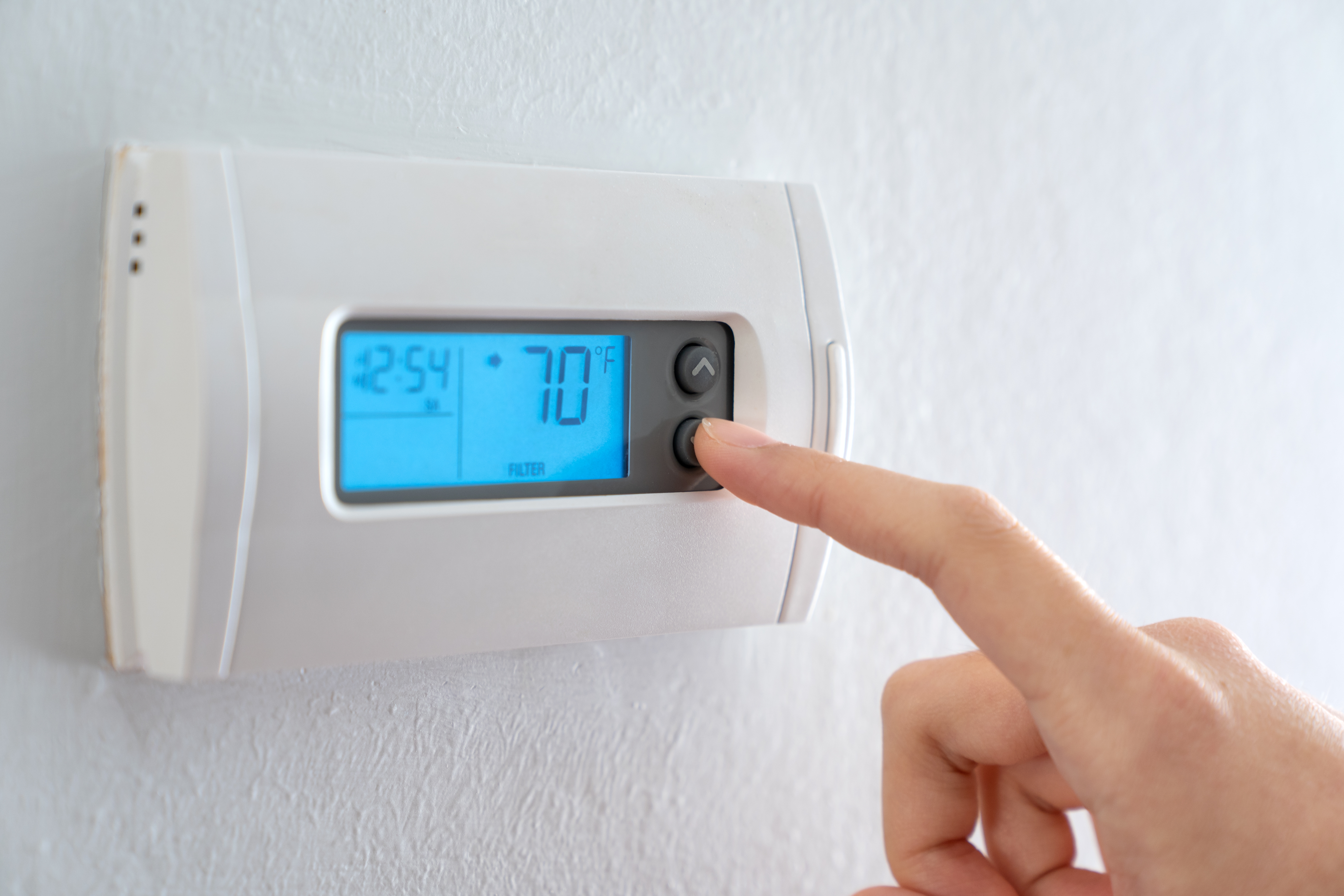 thermostat inside home w finger pressing button