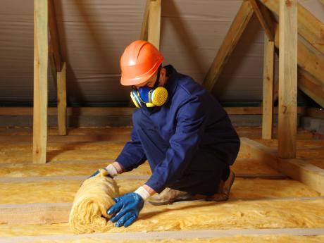 Worker insulating an attic.